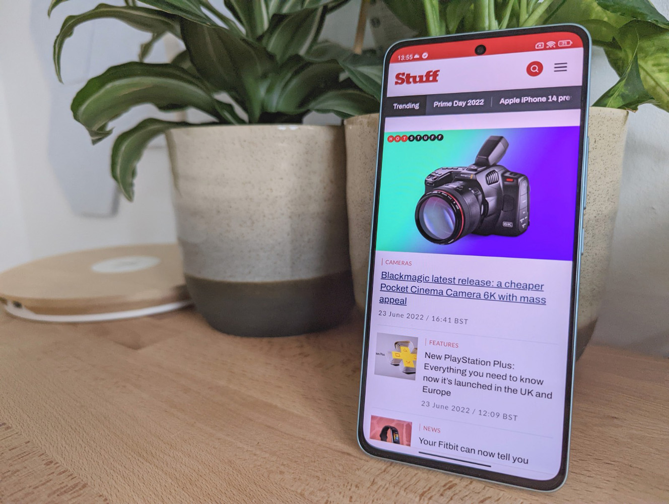 Stuff Xiaomi 12 Lite smartphone review phone showing Stuff website next to plant pot