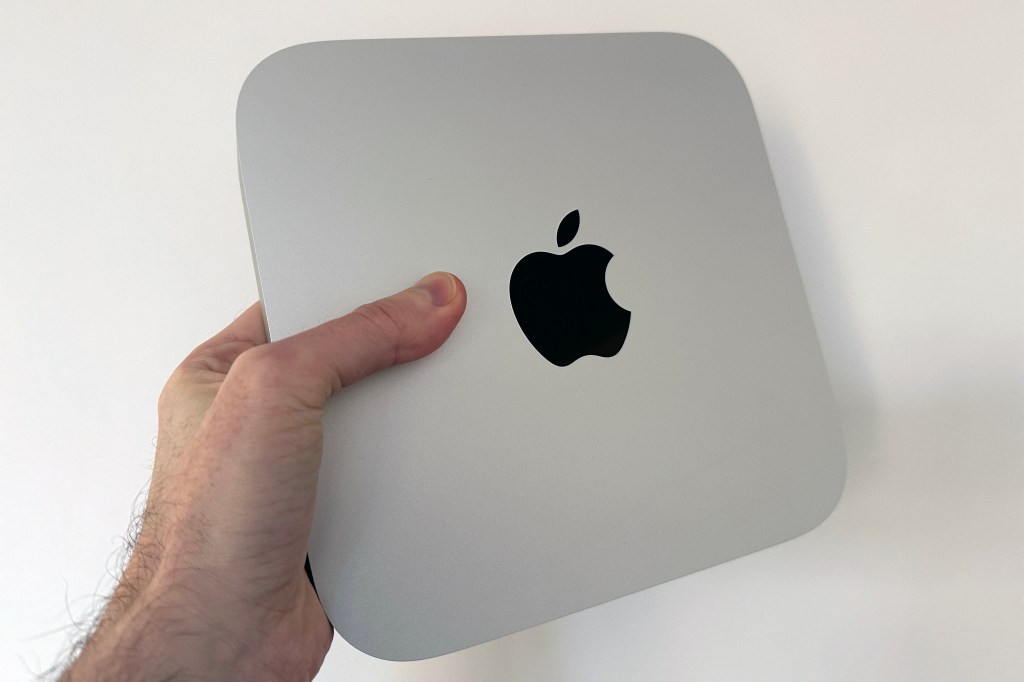 Someone holding up the Mac Mini M2