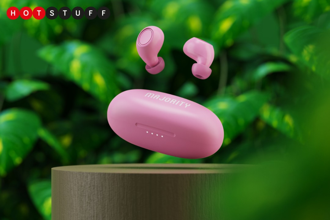 Majority's pink biodegradable earbuds in front of plants