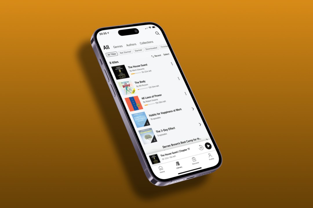 Audible app open on iPhone in front of orange background