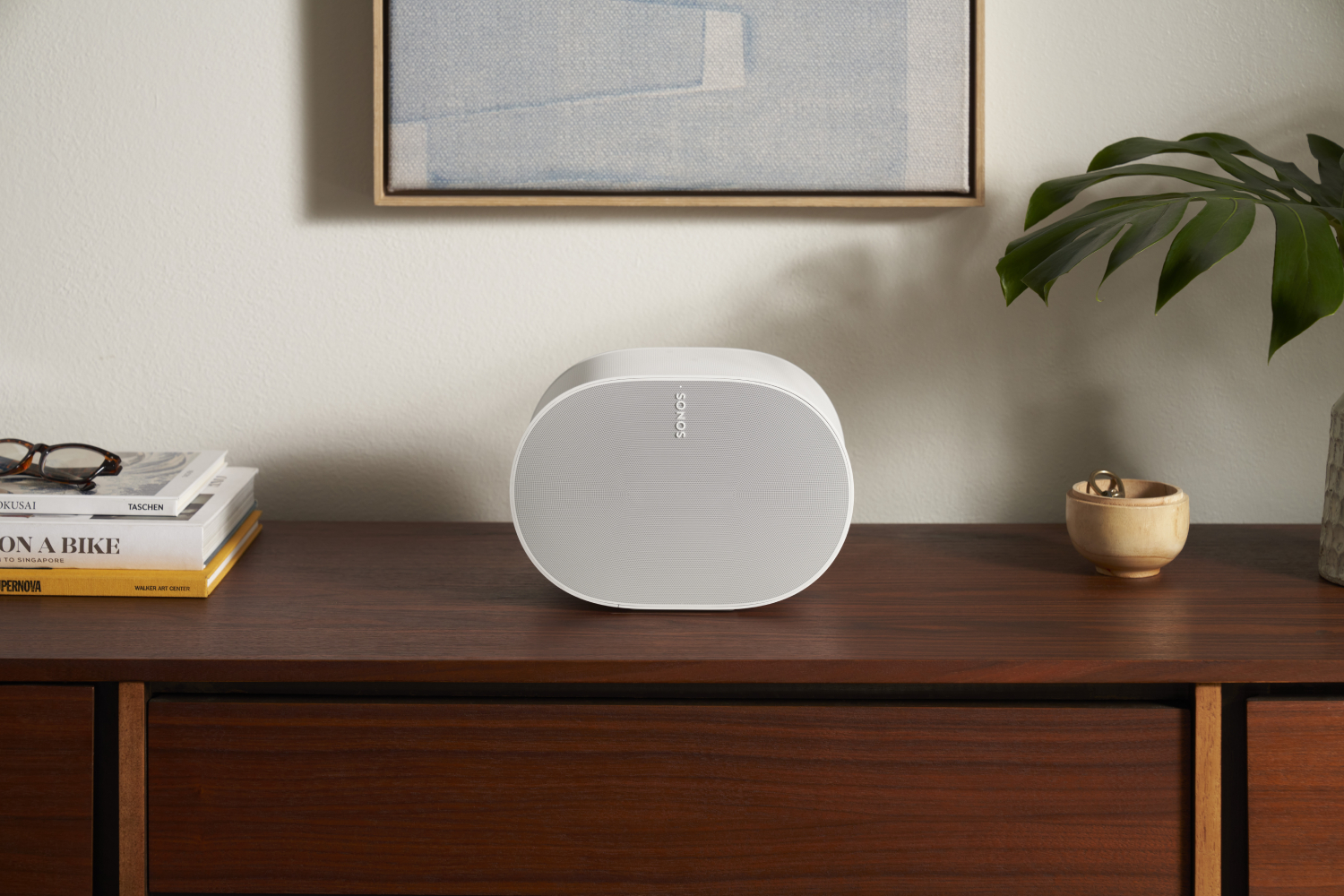 A Sonos Era 300 speaker in white on a sideboard.