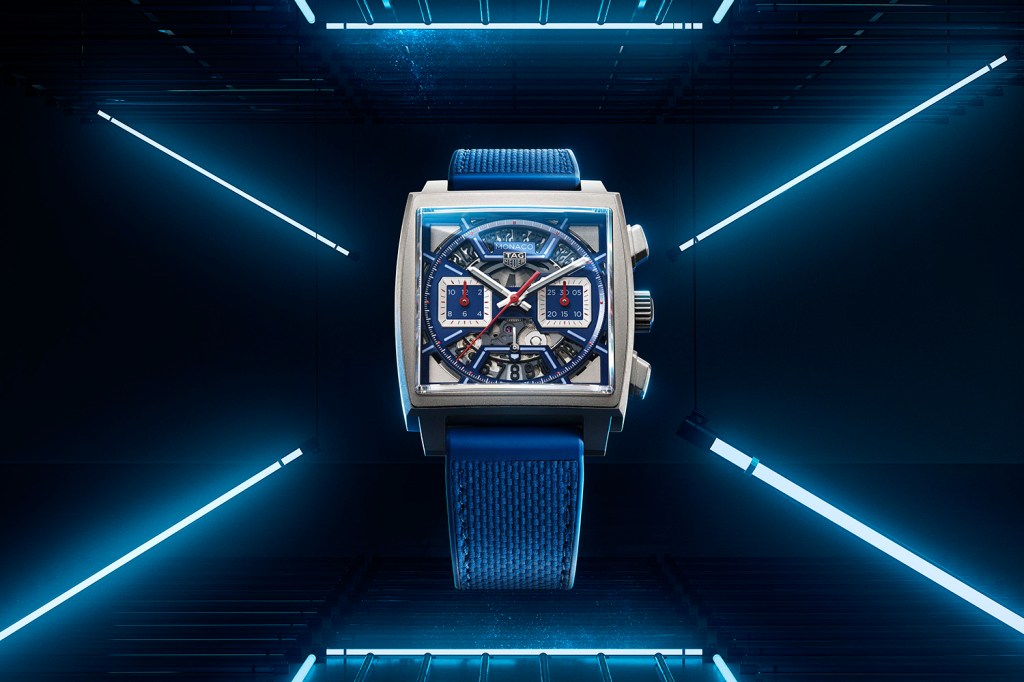 Blue TAG Heuer Monaco Skeleton dial on a black background surrounded by neon lights.