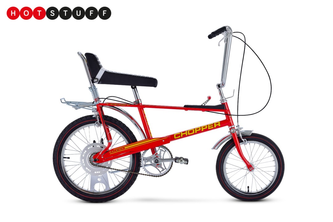 Side view of a red Raleigh Chopper bike on a white background